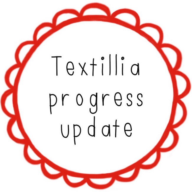 Text reading Textillia progress update in a red scalloped circle border