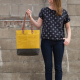 mustard color wool and wax tote in Anna's right hand