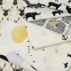 A pile of cream coloured fabrics with black and gold designs.