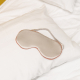 Photo of a sleep mask lying on a pillow.