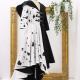 Three-quarter view photo of the Cruella Coat, a high-low coat, half-black and half-white with black spots, with a train and large black hood, on a dress form.