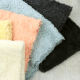 a stack of different colors of faux sherpa fabric