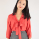 From pattern website. Woman wearing a blouse with pin tucks and a bow on the front and three-quarter sleeves
