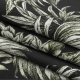 Black fabric with grey/green botanical motifs. Fabric is folded several times.