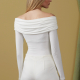 white model wearing a close-fitting white bodysuit with off-the-shoulder ruched cowl neck, from behind