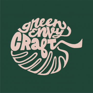 a pink logo of a monstera leaf with the words Green envy craft making up part of the upper half of the leaf on a dark green background.