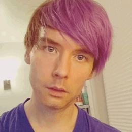 attractive young man with lavender hair smiling slightly